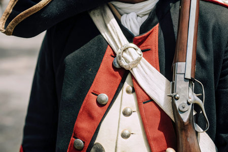 A meticulously crafted dark blue coat with red accents, alongside a white scarf and silver belt buckle, evokes a sense of historical military precision. A wooden rifle with a bayonet completes the ensemble, creating a strong visual narrative.の素材