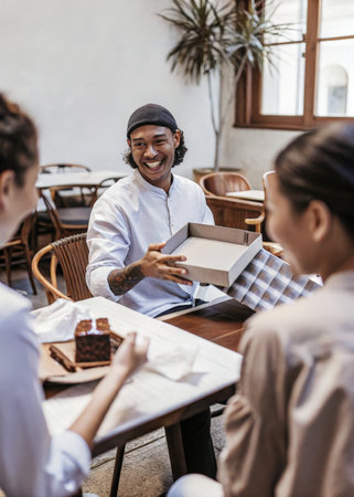 a man and woman sitting at a table with a pizzaの素材