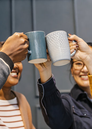 two people holding up cups in the airの素材