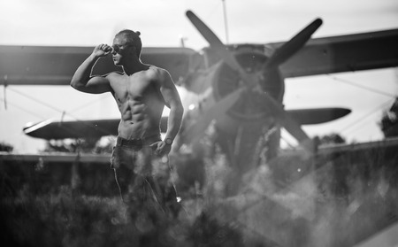 A handsome guy is standing by the plane. Black and white photo.の写真素材