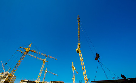 Large construction cranes. High and heavy construction machinery. Construction of  houses....