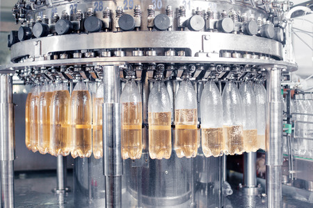 The process of filling bottles with soda water on the production line.の写真素材