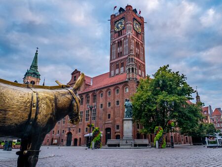 Torun, Poland. 17 July 2019. Medieval Town Hall in the Old Town of Torun with the monument of...