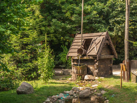 Old well with a crane in a green garden.の写真素材