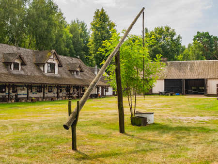 Old well with a crane in a green garden.の写真素材