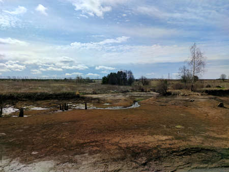 beautiful blue sky with clouds over a dried pond on a sunny day