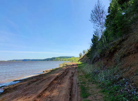 blue sky over the slope near the river bank on a sunny dayの写真素材