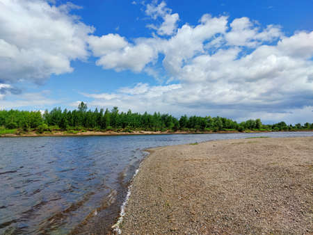 blue sky with clouds over the turn of the river on a sunny dayの写真素材