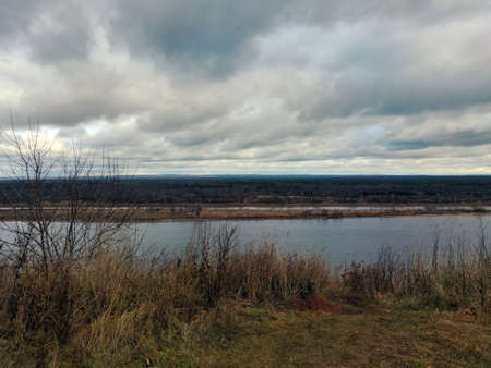 river on the background of the evening cloudy sky in the autumn landscape