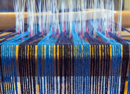 Turquoise and black warp threads at the back of a floor loomの写真素材