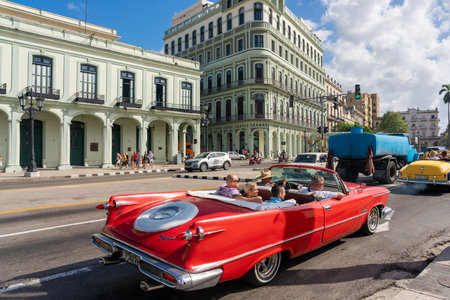 Classic convertible car with tourists on a tour in the streets of old Havana on a sunny day. Havana. Cuba. January 10, 2020.のeditorial素材