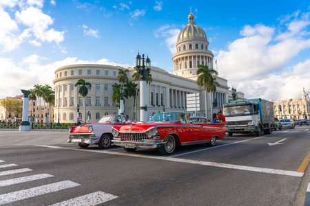 Classic car waiting for the change of light of a traffic light in Prado avenue with the Capitolio of Havana in the background. Havana. Cuba. January 6, 2020.のeditorial素材
