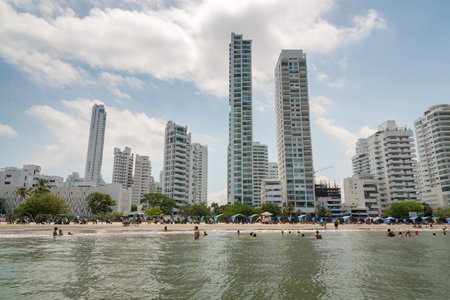 A common beach day in Cartagena with modern buildings in the background. June 23, 2018. Cartagena. Colombiaのeditorial素材