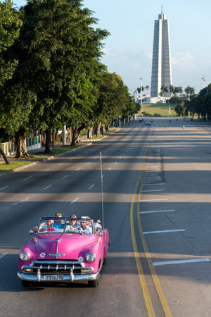 Pink taxi with tourists on the avenue that leads to the Palza de la Revolución one of the most...