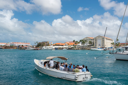 Classic boat with tourists aboard leaving the dock to take a tour around the coasts of the island. Oranjestad. Aruba. February 23, 2019のeditorial素材