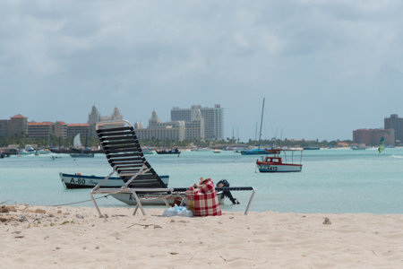 Chair on the beach on sand with luxury hotel facilities in the background on Aruba beach. Palm beach Aruba. February 24, 2019のeditorial素材