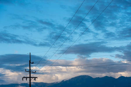 Electric pole in a rural area with mountain ranges in the background. Colombia.の写真素材