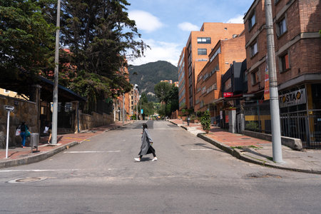 Woman crossing the street without any traffic as a result of the quarantine declared by the state as a measure to prevent the spread of the coronavirus. BogotÃ¡. Colombia. April 12, 2020.のeditorial素材