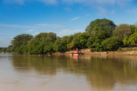 Sand digger on the Sinu river next to a people transport boat. Hunting. Cordova. Colombia . December 13, 2019のeditorial素材