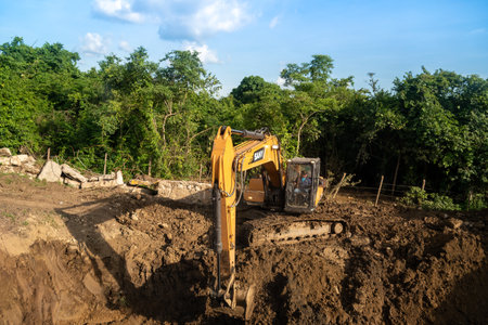 Excavator working in the dirt at the edge of a wet forest. Authentic apartment. Colombia. November 6, 2019のeditorial素材