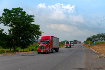 Row of cargo trucks on rural road in tropical climate in Colombia. Cauca Valley. Colombia. 6th November 2019のeditorial素材