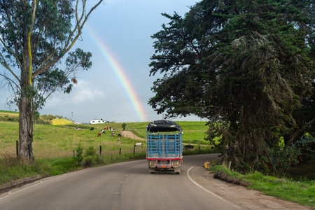 Truck on rural road in a country landscape with a rainbow in the background. BoyacÃ¡. Colombia.の写真素材