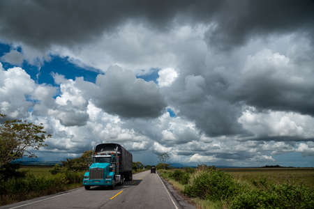 Cargo transport truck on a rural road in a landscape of the Colombian plains.の写真素材