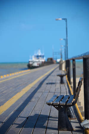Wooden bench on the marine walkway on a beach in the city of Riohacha. Department of La Guajira Colombia.の写真素材