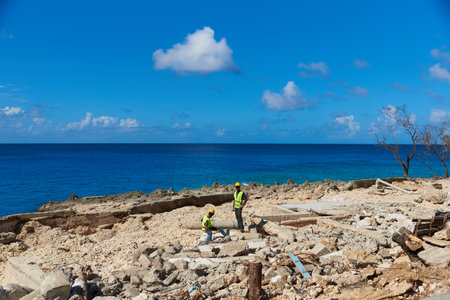 Construction workers on some debris left by Hurricane Iota on the seashore. Island of San Andres. Colombia. December 12, 2020.のeditorial素材