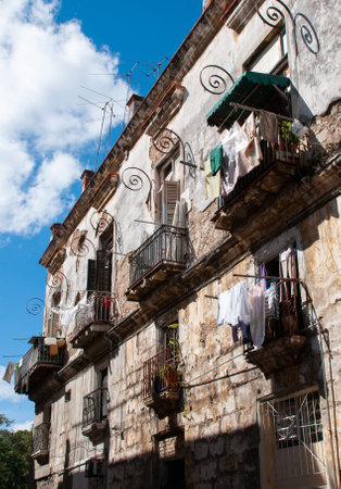 Facade of an old building in dilapidated condition with sheets hanging on the balconies. Havana. Cuba. January 29, 2011のeditorial素材