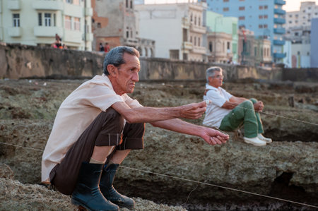 Mature man fishing on the rocks of the wall of the Malecon in the part of Old Havana. Havana Cuba January 20, 2011.のeditorial素材