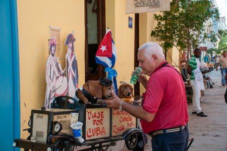 Man with two dogs dressed up with a hat and glasses in a street in Old Havana, Cuba. Havana. Cuba. May 12, 2015のeditorial素材