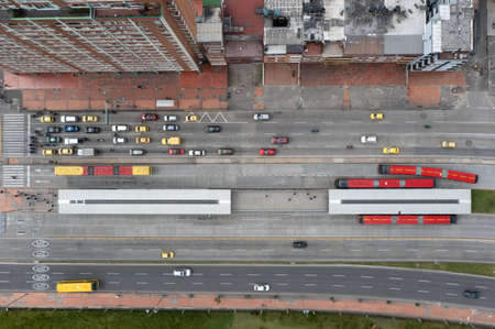 Aerial view of an avenue with vehicular traffic and a public bus station in the city of Bogota....