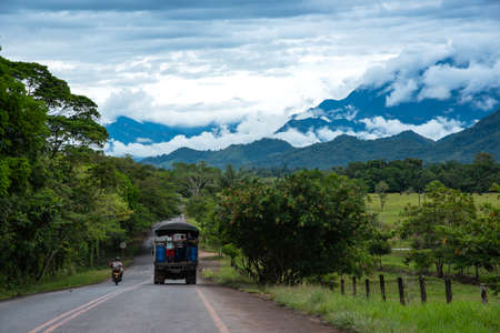 Vehicle driving on a rural road in the rainforest.の写真素材