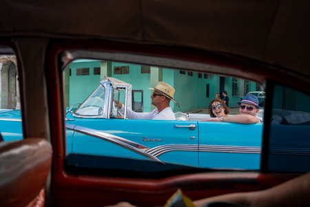 Tourist smiling in a classic convertible car on a street in Old Havana. These means of transport are widely used by tourists who visit the Island. Havana. CubaJanuary 4, 2020.のeditorial素材