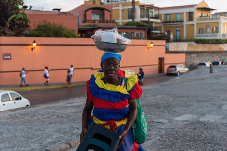 elderly candy seller with colorful and folkloric clothes in the old historic city on the atlantic coast. Cartagena. Colombia. April 24, 2019.のeditorial素材