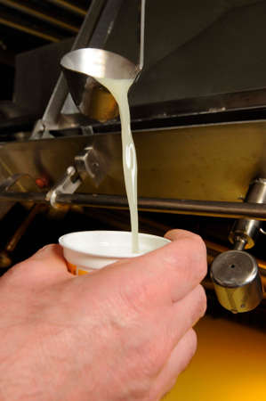 pouring fresh cow's milk into cupの写真素材
