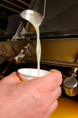 pouring cow's milk into cupの写真素材