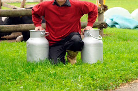 Farmer with two milk cans on his farm