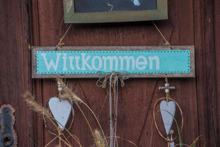 'Willkommen' (welcome) sign on the house doorの写真素材
