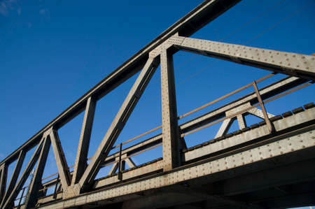 a truss bridge with clear blue sky in the background