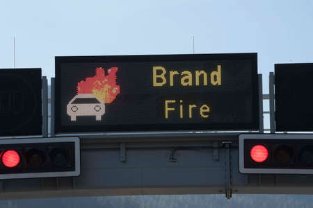 burning car animation on a screen on the highway, red traffic lightsの写真素材
