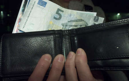 person holding wallet with banknotes in it, five euro banknotes