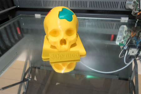 a yellow skull printed in a 3d printer, modern computer technologyの写真素材