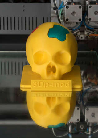 a yellow skull printed in a 3d printer, modern computer technologyの写真素材