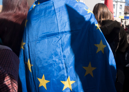 EU citizen wearing a blue EU flag with yellow stars as a capeのeditorial素材