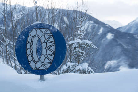 snow chain obligation traffic sign, on a snowy winter roadの写真素材