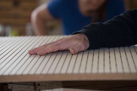 hand of a man on woodwork in a joinery or carpentryの写真素材