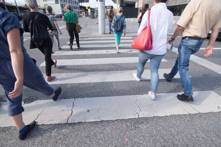 pedestrians walking on a crosswalk on the street, white markingの写真素材