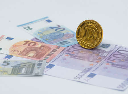 a golden bitcoin coin on banknotes, representing the electronic currency